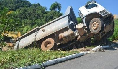 Após descer morro de ré, caminhão fica suspenso em barranco