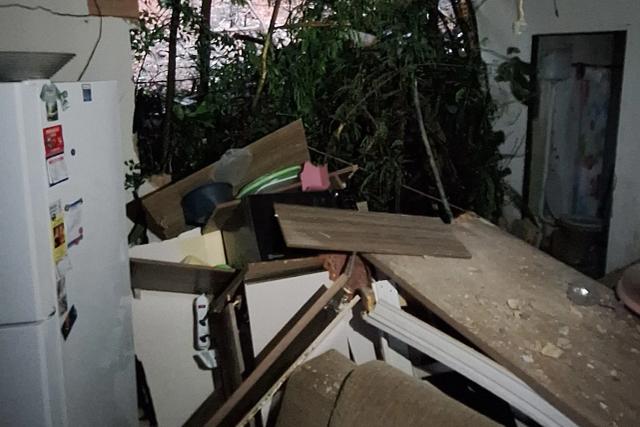 Parede desaba após deslizamento de terra e moradores deixam residência