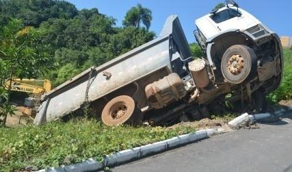 Após descer morro de ré, caminhão fica suspenso em barranco