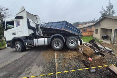 Carreta tomba em morro e atinge muro de residência em Criciúma; veja fotos